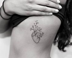 a heart tattoo on the back of a woman's stomach