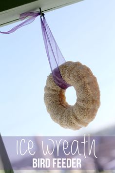 a donut hanging from a string with a purple ribbon