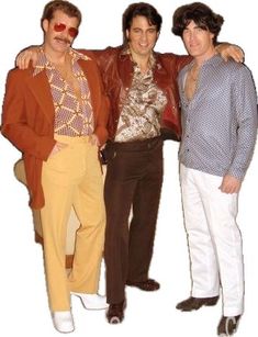 three men standing next to each other in front of a white background with one man wearing a fake mustache