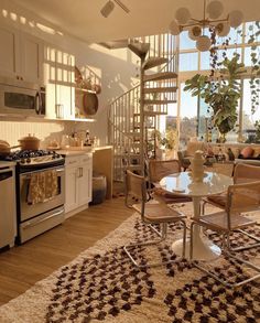 a kitchen with a spiral staircase leading up to the second floor and a dining area