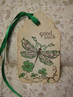 a good luck tag with a dragon on it and shamrocks around the neck hanging from a green ribbon