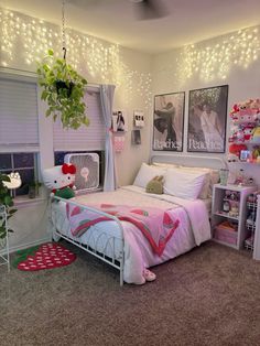 a bedroom decorated in pink and white with lights