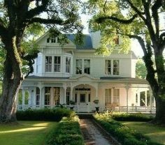 a large white house surrounded by trees and grass