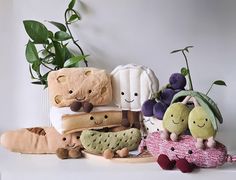 several stuffed animals and plants on a shelf