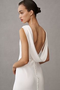 a woman in a white dress with pearls on her back