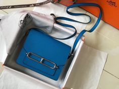 Description HRMS Mini Evercolor Sac Roulis 19 Blue For Women, Handbags, Shoulder Bags 7.5in/19cm Rep 1:1 Size: 19 x 15 x 16 cm / 7.5 x 6 x 6.2 inches (Length x Height x Width) This Hermès Roulis is handcrafted from Evercolour in the colour Beton and detailed with a permabrass clasp. Use the slim strap to style this beautiful Roulis crossbody or over the shoulder. Blue Blue color handle Silver color hardware Mini compartment Adjustable shoulder strap Includes box, dust bag. This product is of the Togo Leather, Stylish Handbags, Luxury Products, Orange Leather, Evening Clutch Bag, Tote Backpack, Bag Tags, New Bag, Birkin Bag