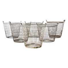 four metal baskets with handles on each side and one is holding two empty glasses in the middle