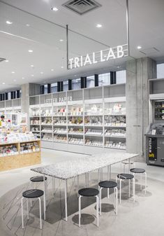 the interior of a retail store with tables and stools