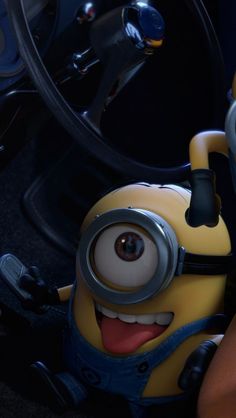 two minion characters sitting next to each other in front of a car steering wheel