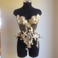 a mannequin is adorned with gold and silver brocades on it's torso