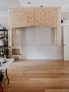 an unfinished room with wood paneling on the wall and shelves in the back ground