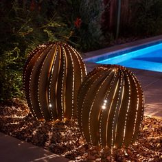 two large cactus shaped lights next to a swimming pool