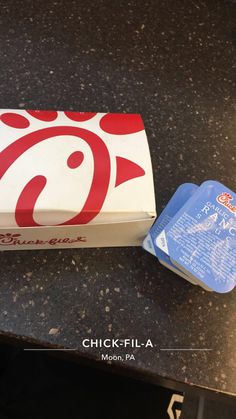 an unopened pizza box sitting on top of a counter next to a blue container