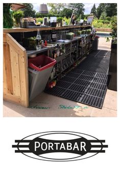 an outdoor bar with lots of bottles and cans on the outside wall, next to a black mat that says portabr