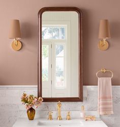 a bathroom with a sink, mirror and two lights on the wall next to it