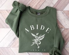 Abide John 15 Sweatshirt, Jesus Lover Christian Sweatshirt, Bible Verse Hoodie, Religious Shirt, Faith Tshirt, Women Christian Gifts  ORDER INSTRUCTIONS  ➤ Check and review all listing photos. ➤ Pick up your item's size and color from drop down menus. ➤ Choose the quantity. ➤ Click "Add to Cart" button. ➤ Fill in the personalization box as recommended if provided.  ➤ You can go back to add more item or you can complete the checkout process. ➤ Click "Proceed to Check Out".  WHICH SIZE FITS ME BEST  ➤ In each listing, you can find pictures showing the variety of colors and body sizes. ➤ Measurements are in inches. ➤ With arms down at side, measure around the upper body, under arms and around the fullest part of the chest.  IMPORTANT  ➤ Due to the nature of the fabric as well as your monitor Christian Gift Shop, Etsy Wishlist, Christian Products, John 1 5, Faith Tshirts, Salt And Light, Christian Tshirt, Diy Sweatshirt, Gift Shops