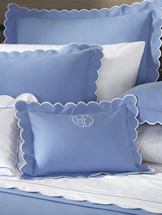 blue and white bedding with scalloped trimmings on the pillowcase