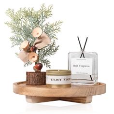 an image of a candle and body cream on a wooden stand next to a pine tree