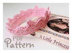 a pink crocheted bracelet sitting on top of a book next to it's cover