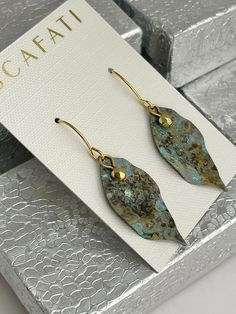 a pair of earrings sitting on top of a card