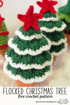 three crocheted christmas trees with red and green stars on top, sitting next to each other