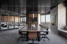 an empty conference room with chairs and a large table in front of the window looking out onto the city