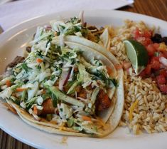 two tacos and rice on a white plate