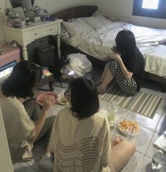 three people sitting on the floor eating food