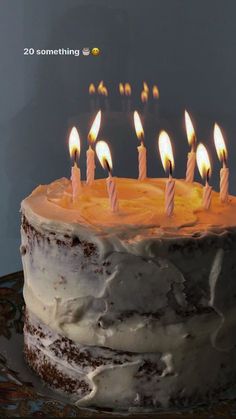 a cake with white frosting and lit candles