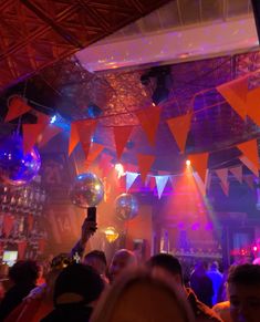 a group of people at a party with disco balls hanging from the ceiling