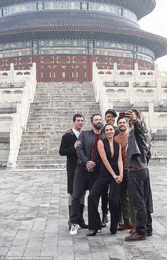 a group of people standing next to each other in front of a building with stairs