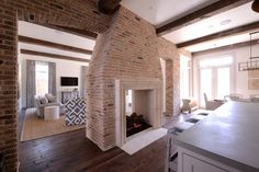 a living room filled with furniture and a fire place in the middle of a kitchen