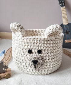 a white knitted basket with a bear face on it