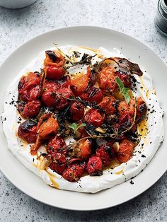 a white plate topped with food next to a bowl