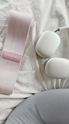 a pair of headphones sitting on top of a bed next to a pink neck tie