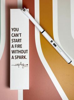 a white pen sitting on top of a piece of paper next to a sign that says you can't start a fire without a spark