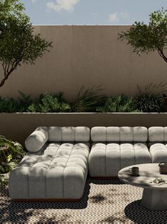 a couch and table on a patio with trees in the backgroung area