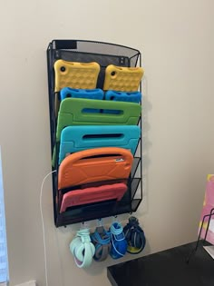 there is a black rack with many different cases on it and shoes next to the wall