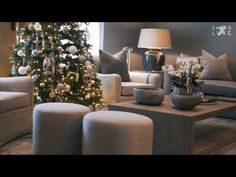 a living room filled with lots of furniture and a christmas tree in the middle of it