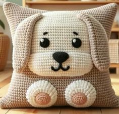 a crocheted dog pillow sitting on top of a wooden floor