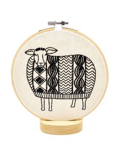 a black and white sheep is shown on the front of a hand embroidered hoop frame