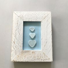 three hearts in a white frame on a wall