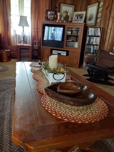 a living room filled with furniture and a flat screen tv on top of a wooden table