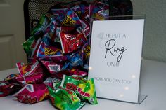 a pile of candy sitting on top of a table next to a sign that says he put a ring on it