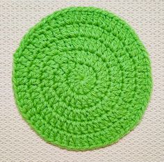 a green crocheted round on a white surface with the center in the middle