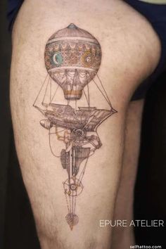 a woman's thigh with a tattoo on it that has an image of a hot air balloon flying through the sky