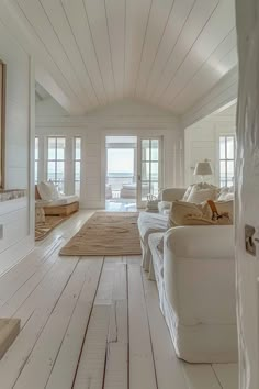 a living room with white furniture and wood floors on the floor is pictured in this image