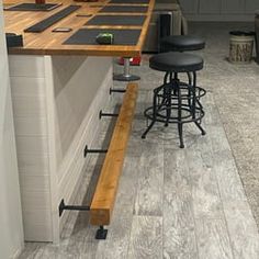 a kitchen with an island and stools in the center, next to a bar