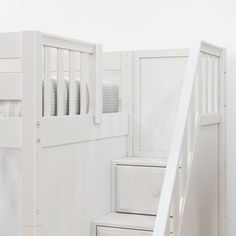 a white bunk bed next to a set of drawers and a ladder in a room