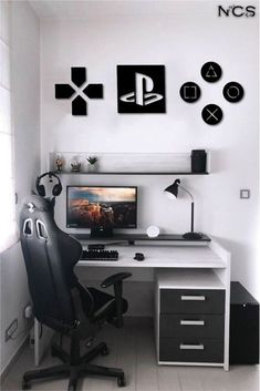 a desk with a computer on top of it in front of a wall mounted video game controller